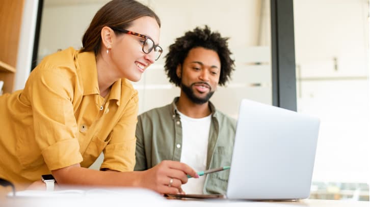 duas pessoas trabalhando juntas em um laptop